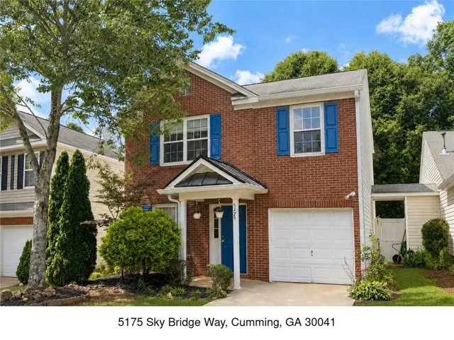 Brick exterior with blue shutters, covered entry, and attached garage
