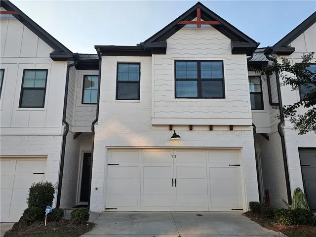 White brick facade, black-framed windows, and shingle siding