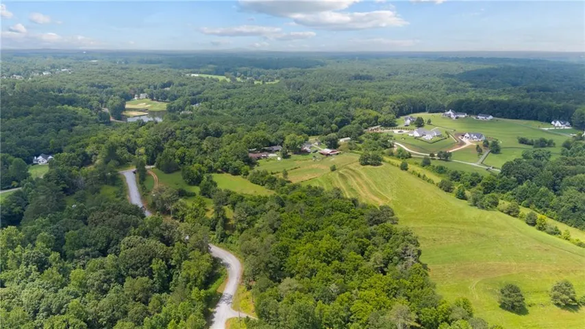 Expansive aerial perspective showcasing a verdant landscape with rolling green hills
