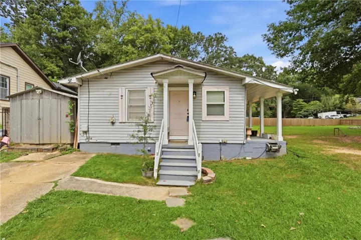 Front elevation with light-colored siding and a covered front porch
