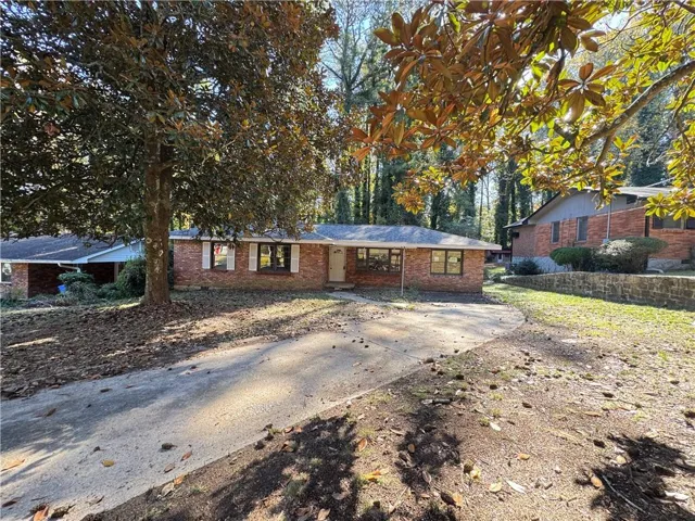 Ranch-style home with brick siding and concrete driveway