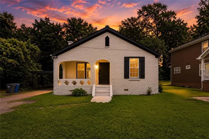 White painted brick exterior with a black roof and shutters