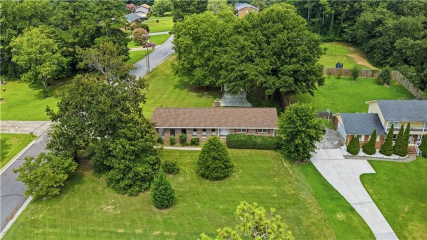Ranch-style residence featuring a brick facade and a brown shingle roof