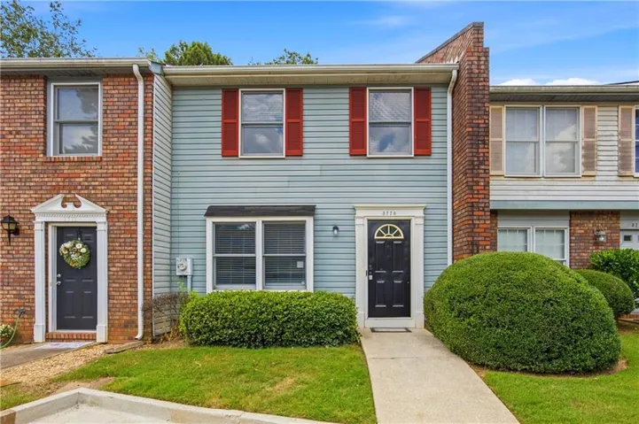 Two-story exterior with light blue horizontal siding and red window shutters