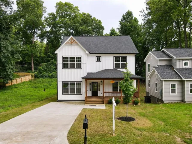 Modern farmhouse exterior with white vertical siding and black-trimmed windows
