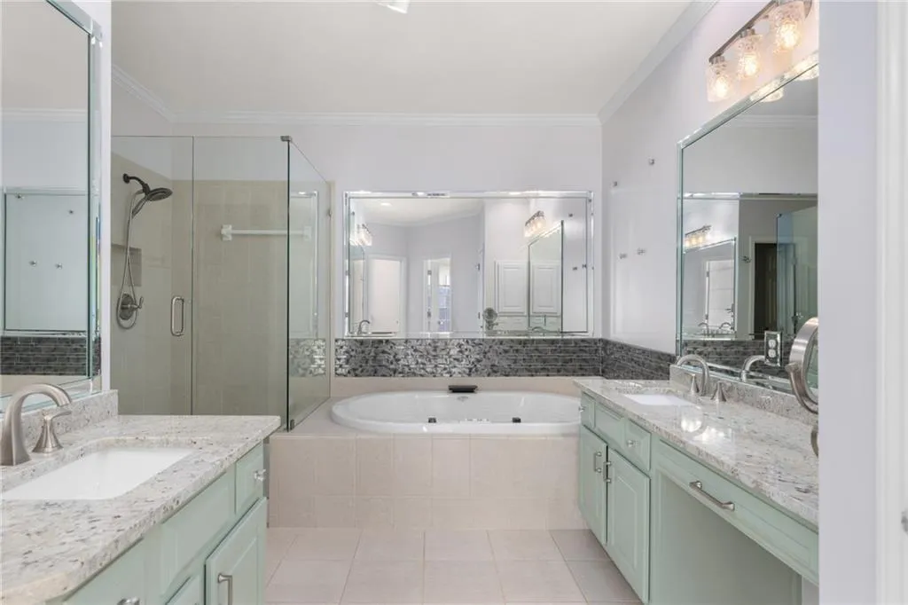 Bathroom with a shower stall, crown molding, a sink, a bath, and tile patterned flooring