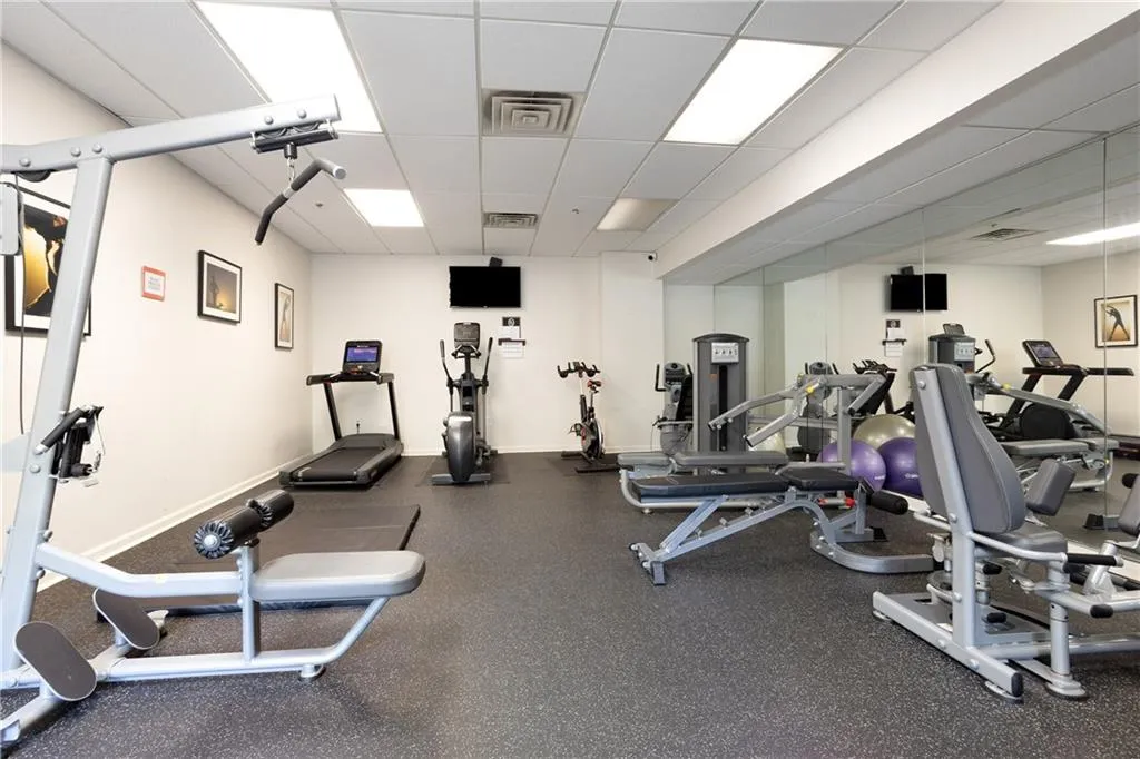 Workout area featuring a paneled ceiling and baseboards