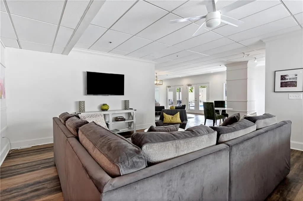 Living area with a ceiling fan, french doors, a paneled ceiling, and dark wood-style flooring