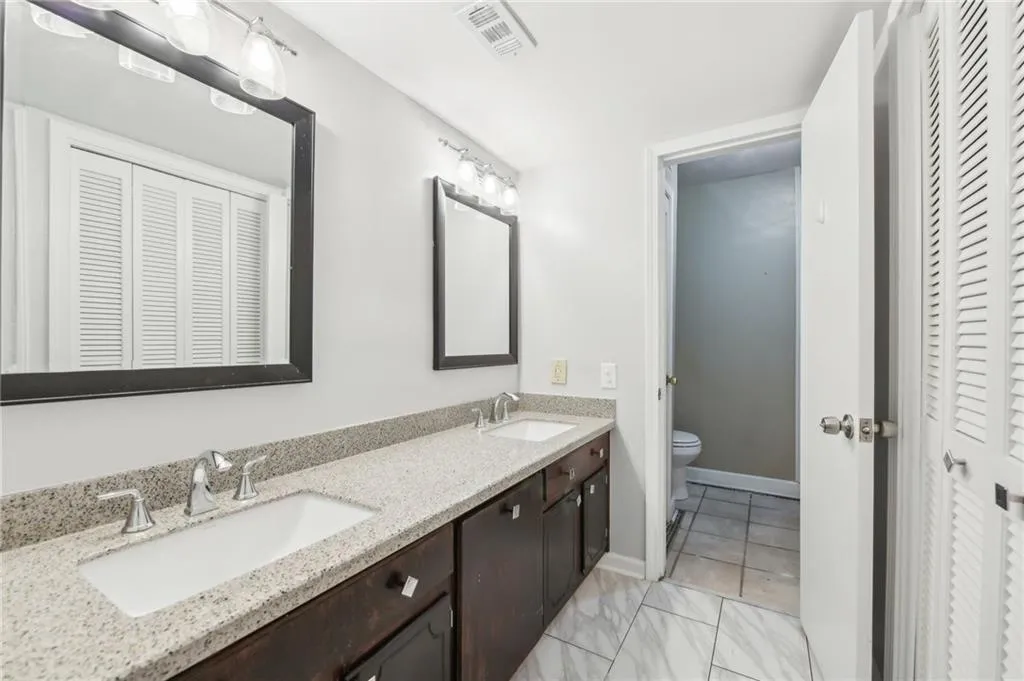 Full bathroom featuring a closet and double vanity