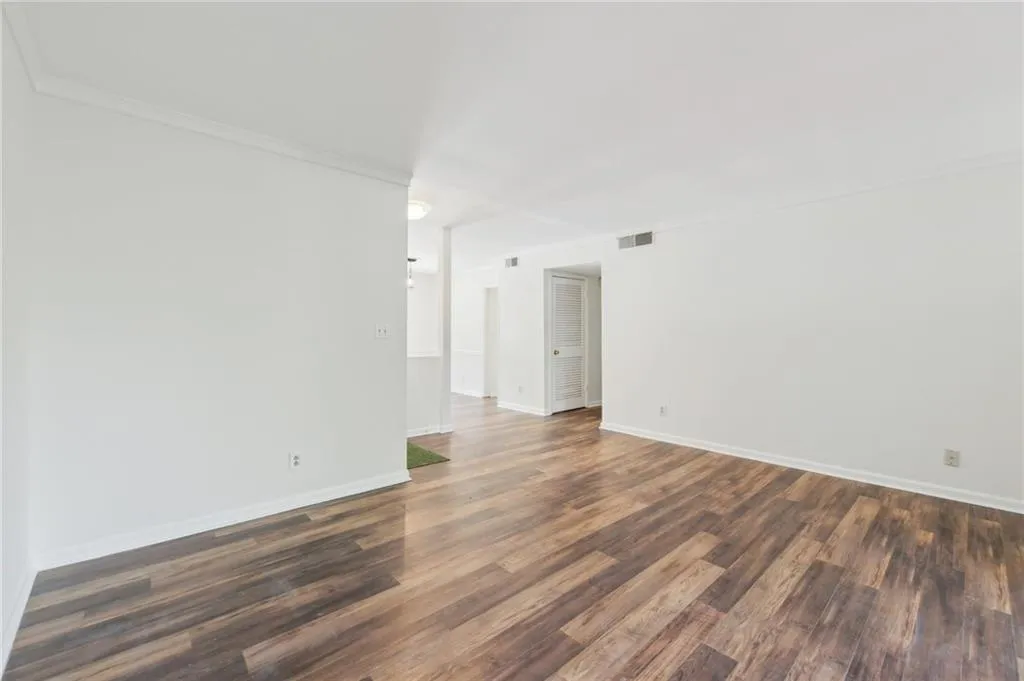 Empty room with dark wood finished floors and ornamental molding