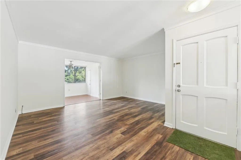 Empty room featuring ornamental molding and dark wood finished floors