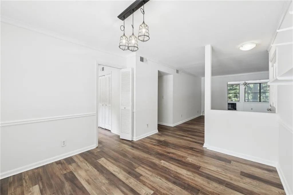 Empty room with ornamental molding and dark wood finished floors