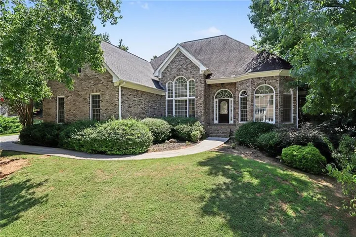 Brick exterior with a gabled roof, arched windows, and a curved walkway