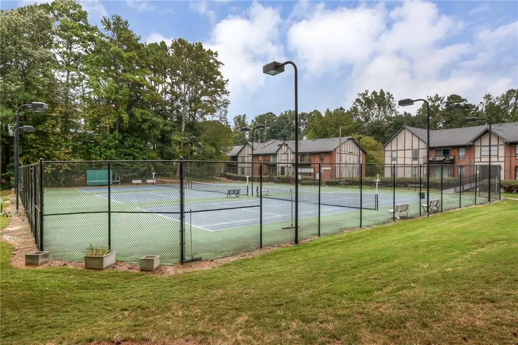 View of tennis court with a residential view