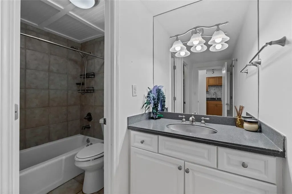 Full bathroom featuring tile patterned floors, toilet, vanity, and bathing tub / shower combination