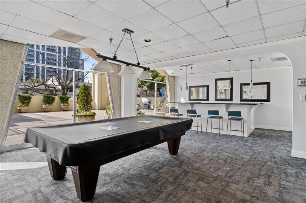 Recreation room featuring arched walkways, a paneled ceiling, billiards, and carpet
