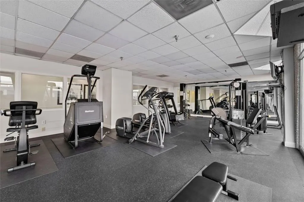 Exercise room featuring baseboards and a paneled ceiling