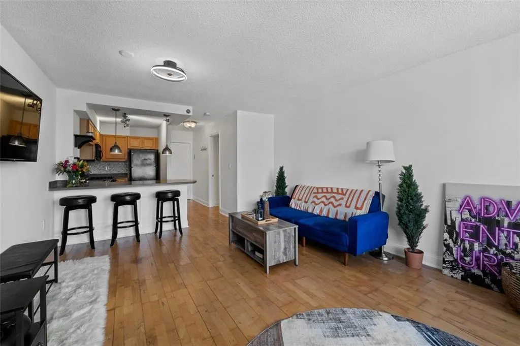 Living area with baseboards, a textured ceiling, and hardwood / wood-style floors
