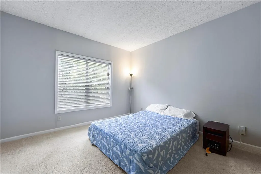 Bedroom with a textured ceiling and carpet