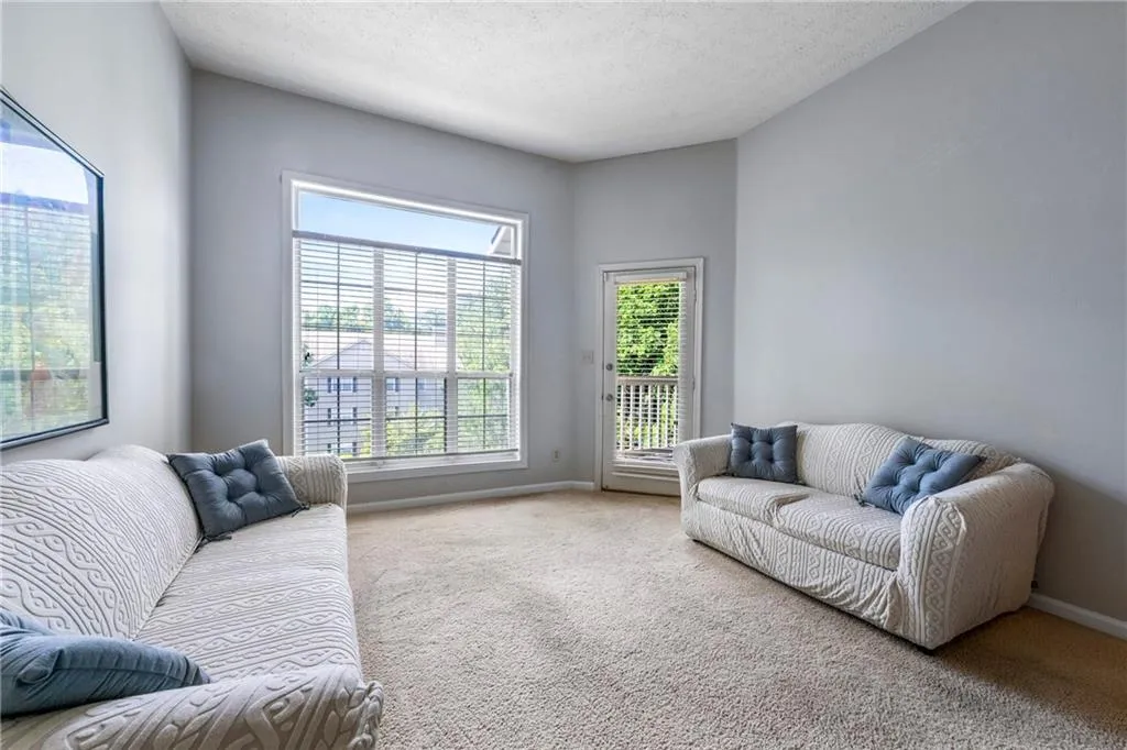 Living area with carpet floors and a textured ceiling