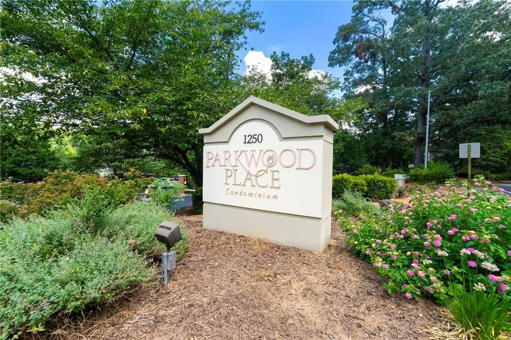 Community / neighborhood sign featuring view of wooded area