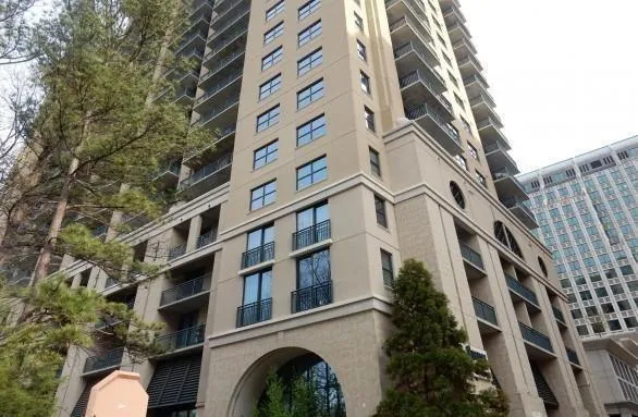 High-rise building with a beige facade and multiple private balconies
