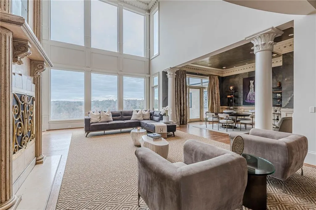 Living area with ornate columns, a high ceiling, and ornamental molding