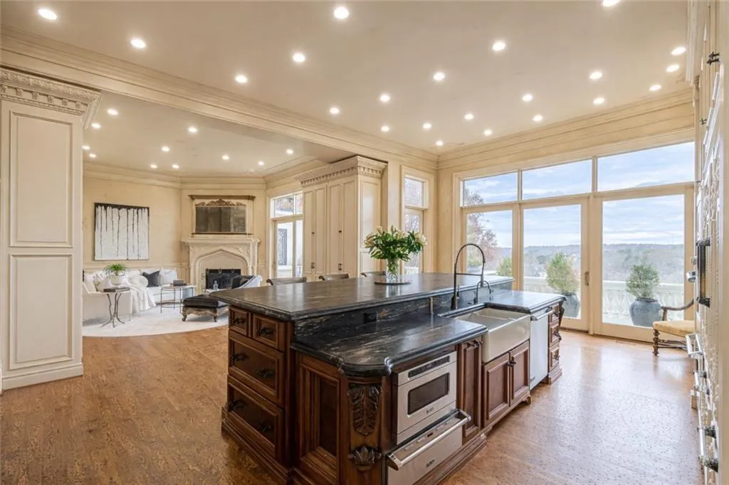 Kitchen featuring a kitchen island with sink, a fireplace, a warming drawer, open floor plan, and recessed lighting