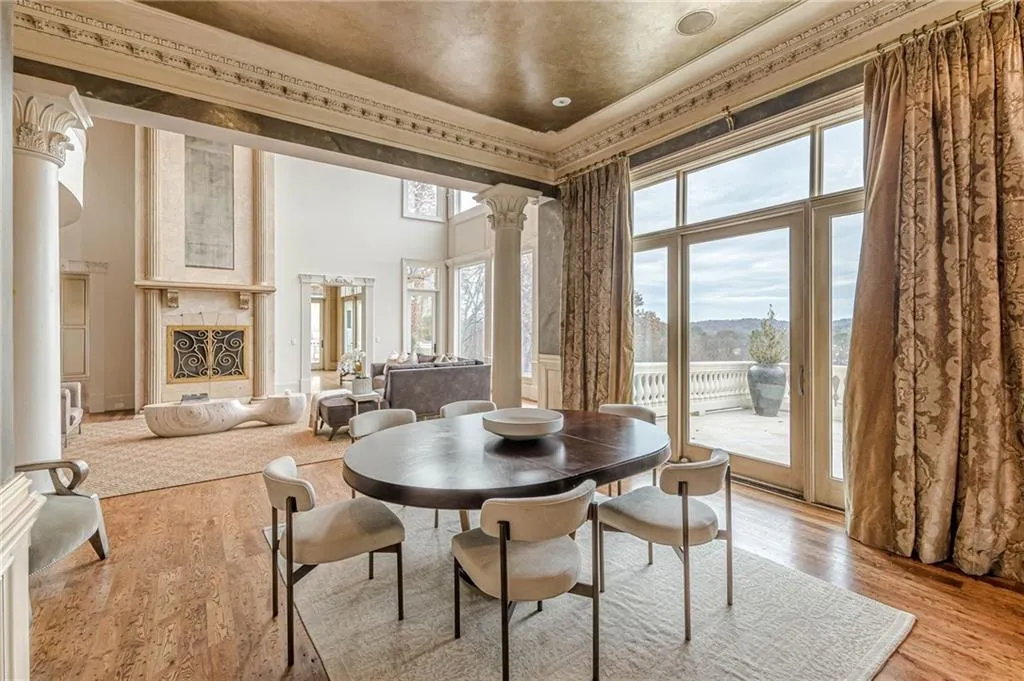 Dining room with ornate columns, wood finished floors, ornamental molding, and a high ceiling