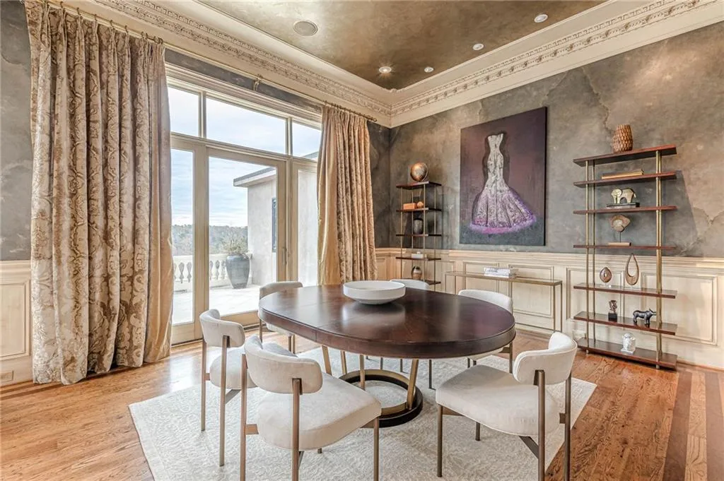 Dining area with ornamental molding, a wainscoted wall, a decorative wall, and light wood-style flooring