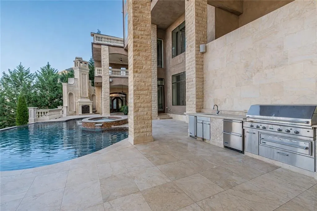 View of pool with area for grilling, a patio area, a pool with connected hot tub, and a balcony