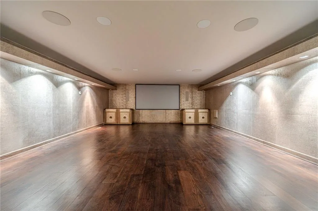 Cinema with wallpapered walls and dark wood finished floors