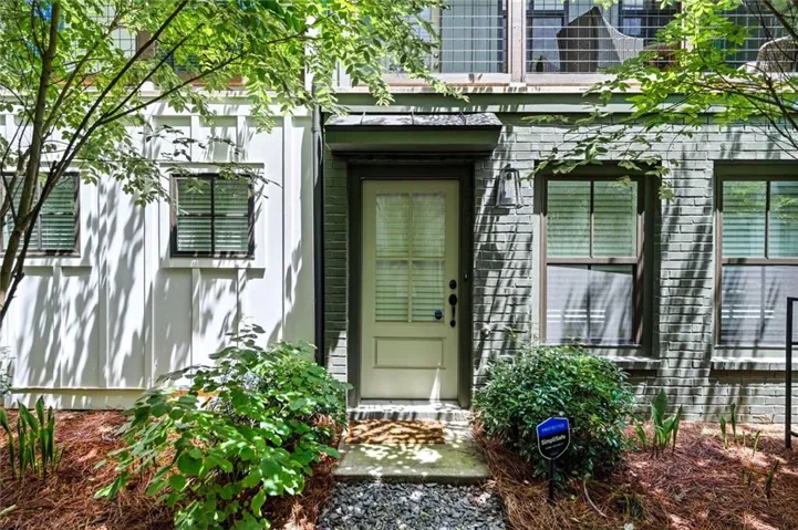 Board and batten siding, brick exterior, transom window, covered entry, and gravel path