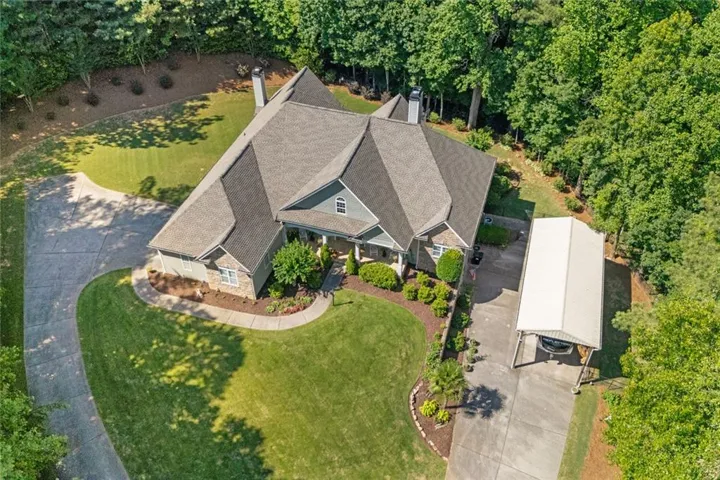 Aerial View – Bird's-eye view showcasing the expansive homesite, RV-ready setup, and private setting surrounded by mature trees for added privacy.