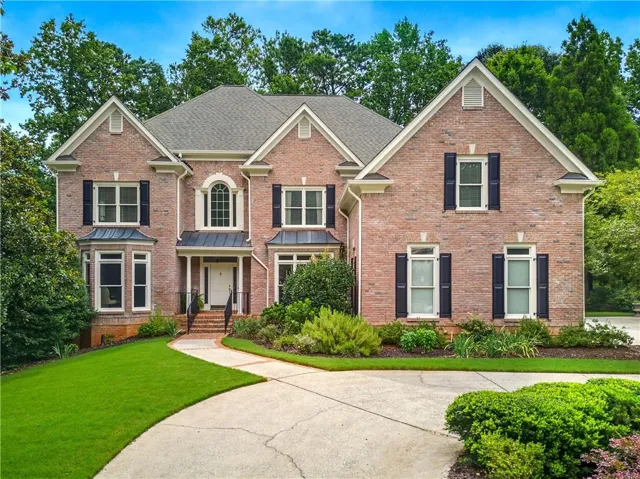 Brick exterior with multiple gables and a gray shingle roof