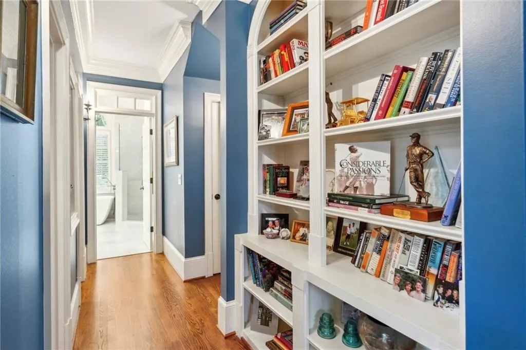 Corridor with light wood-style flooring and crown molding