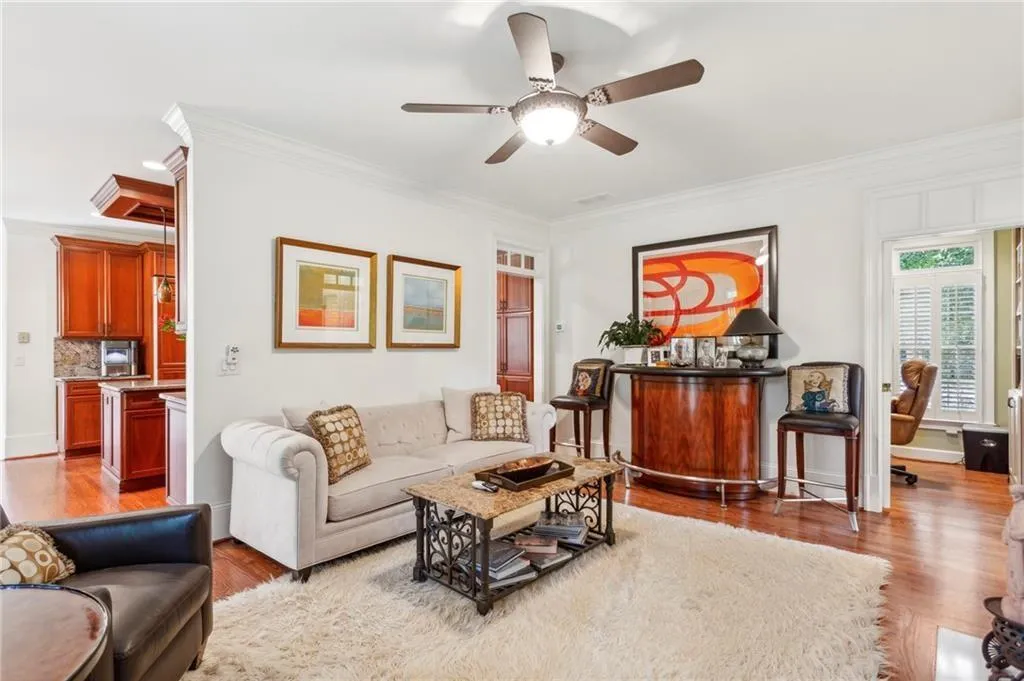 Living room featuring ornamental molding, wood finished floors, and ceiling fan