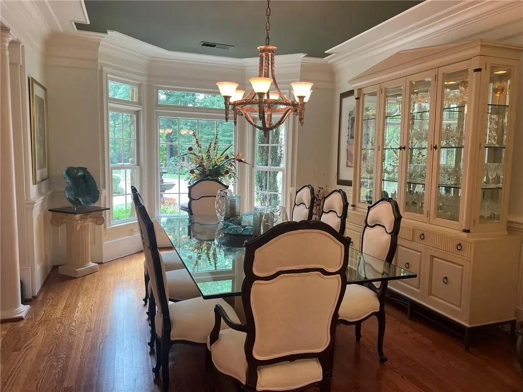 Dining space featuring crown molding, wood finished floors, and a chandelier