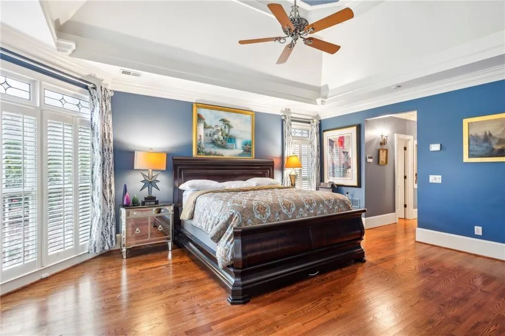 Bedroom featuring crown molding, wood finished floors, and a ceiling fan