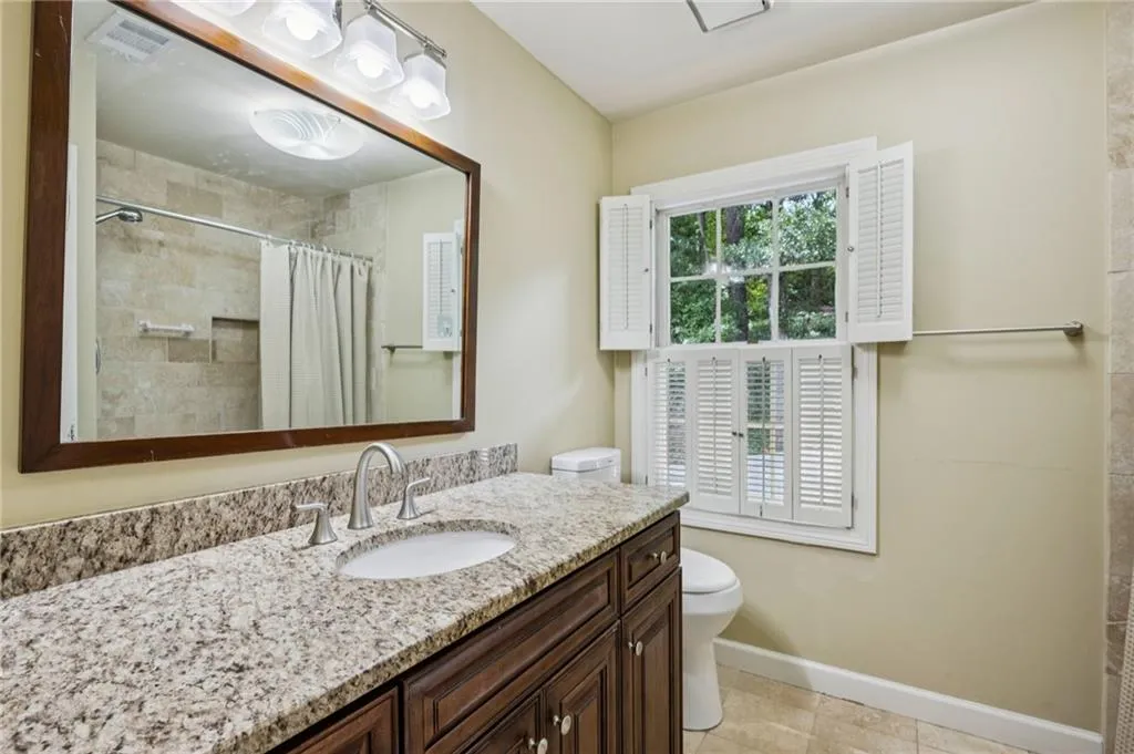 Full bathroom with vanity, light tile patterned floors, and a tile shower