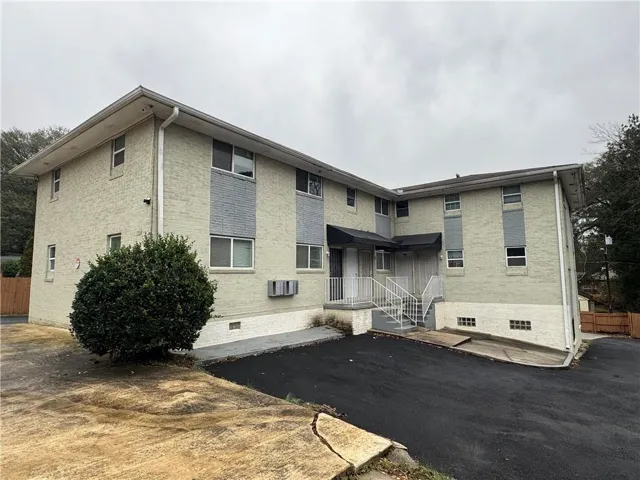 Rear view of property featuring brick siding, crawl space, and a patio area