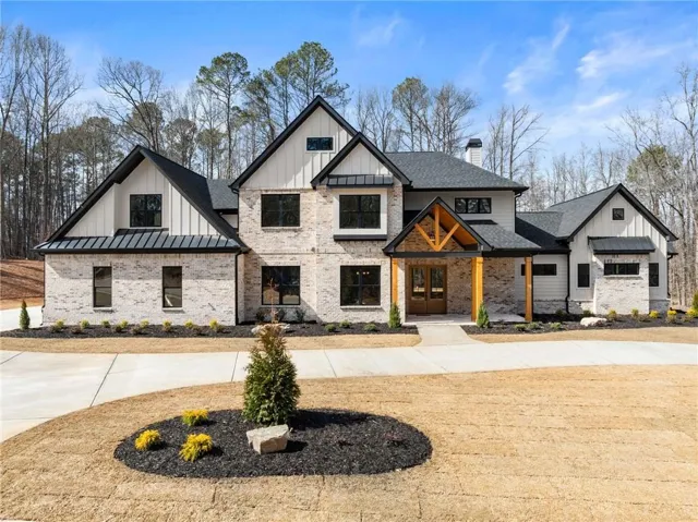 Modern farmhouse exterior with light-colored brick and vertical white siding