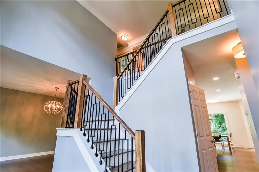 Stairs featuring an inviting chandelier and hardwood / wood-style floors