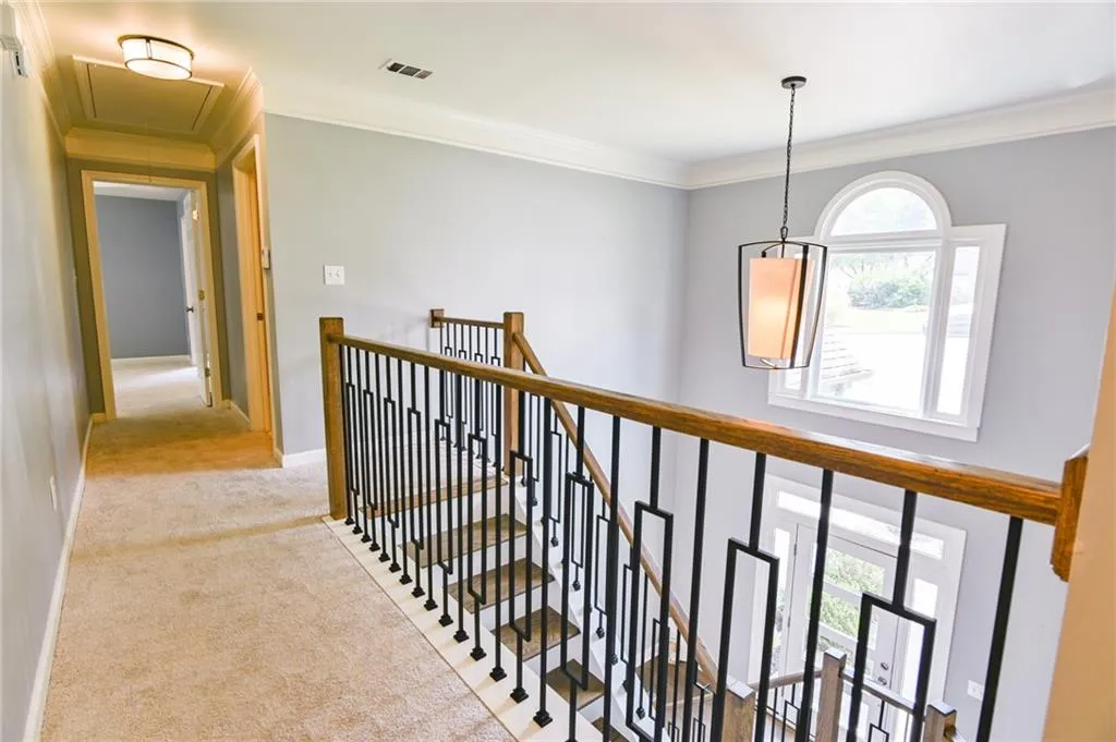 Hallway featuring light carpet and crown molding