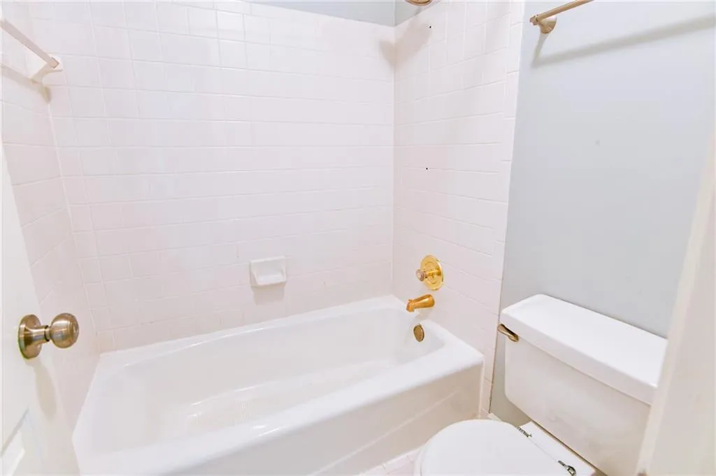 Bathroom with toilet and tiled shower / bath combo