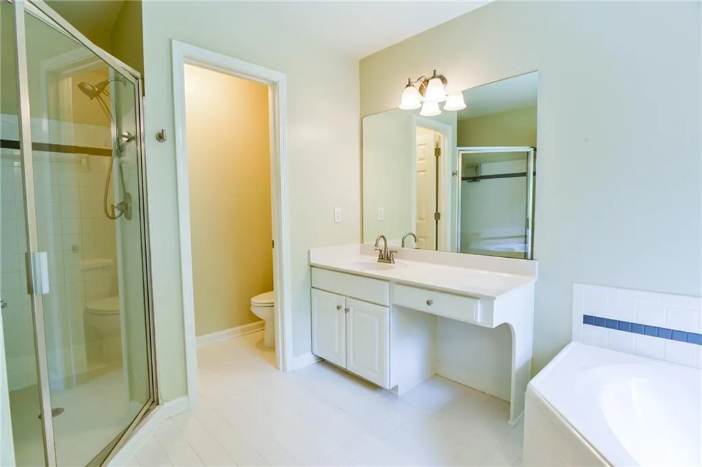Full bathroom featuring tile patterned flooring, vanity, toilet, and independent shower and bath
