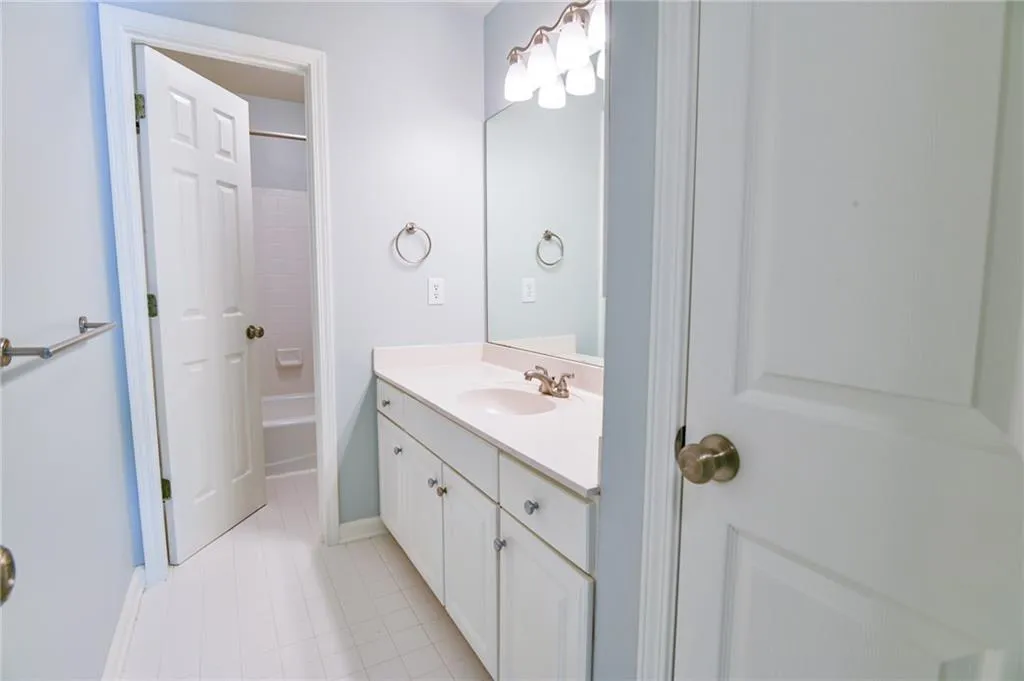 Bathroom featuring vanity, tile patterned floors, and  shower combination