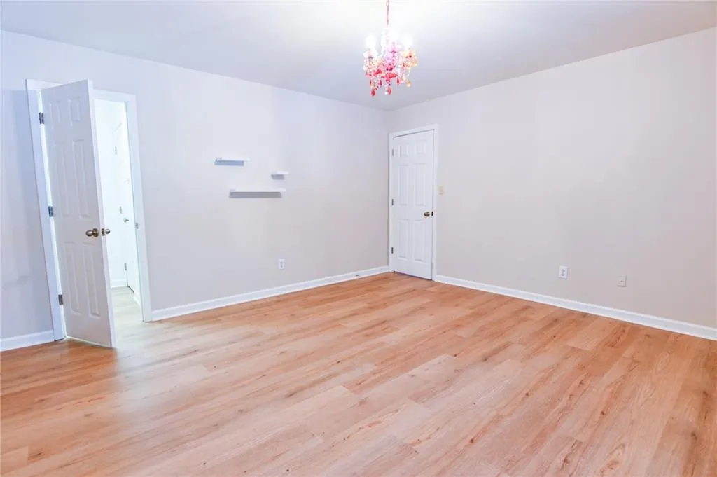 Empty room featuring an inviting chandelier and light hardwood / wood-style floors