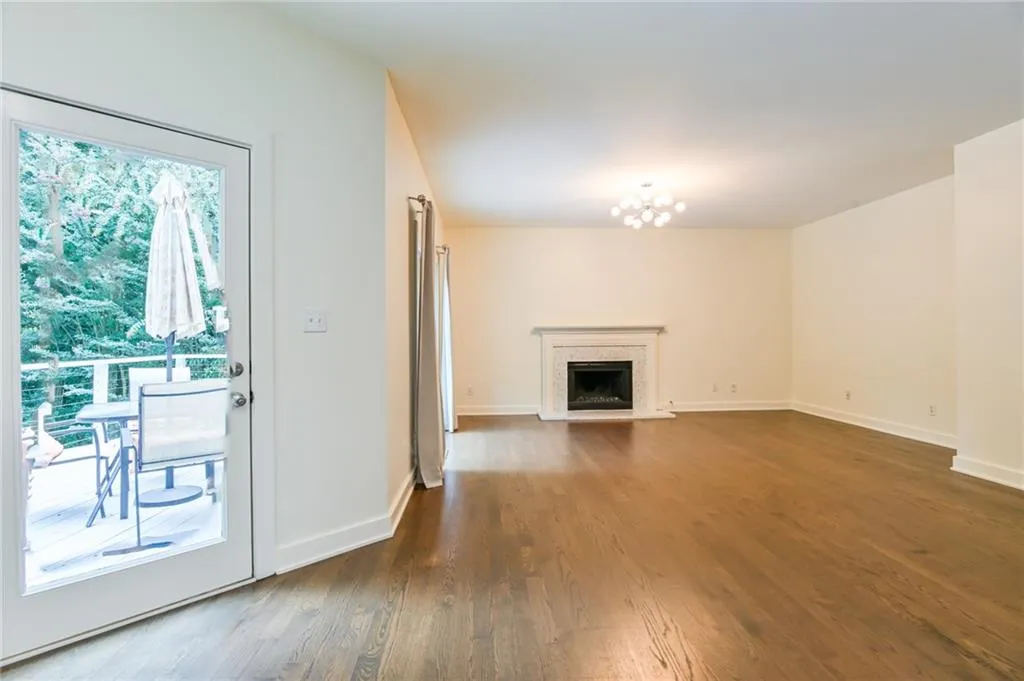 Unfurnished living room with a wealth of natural light, dark hardwood / wood-style flooring, and a premium fireplace