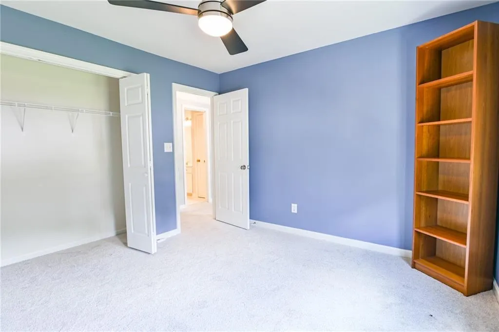 Unfurnished bedroom with carpet flooring, ceiling fan, and a closet